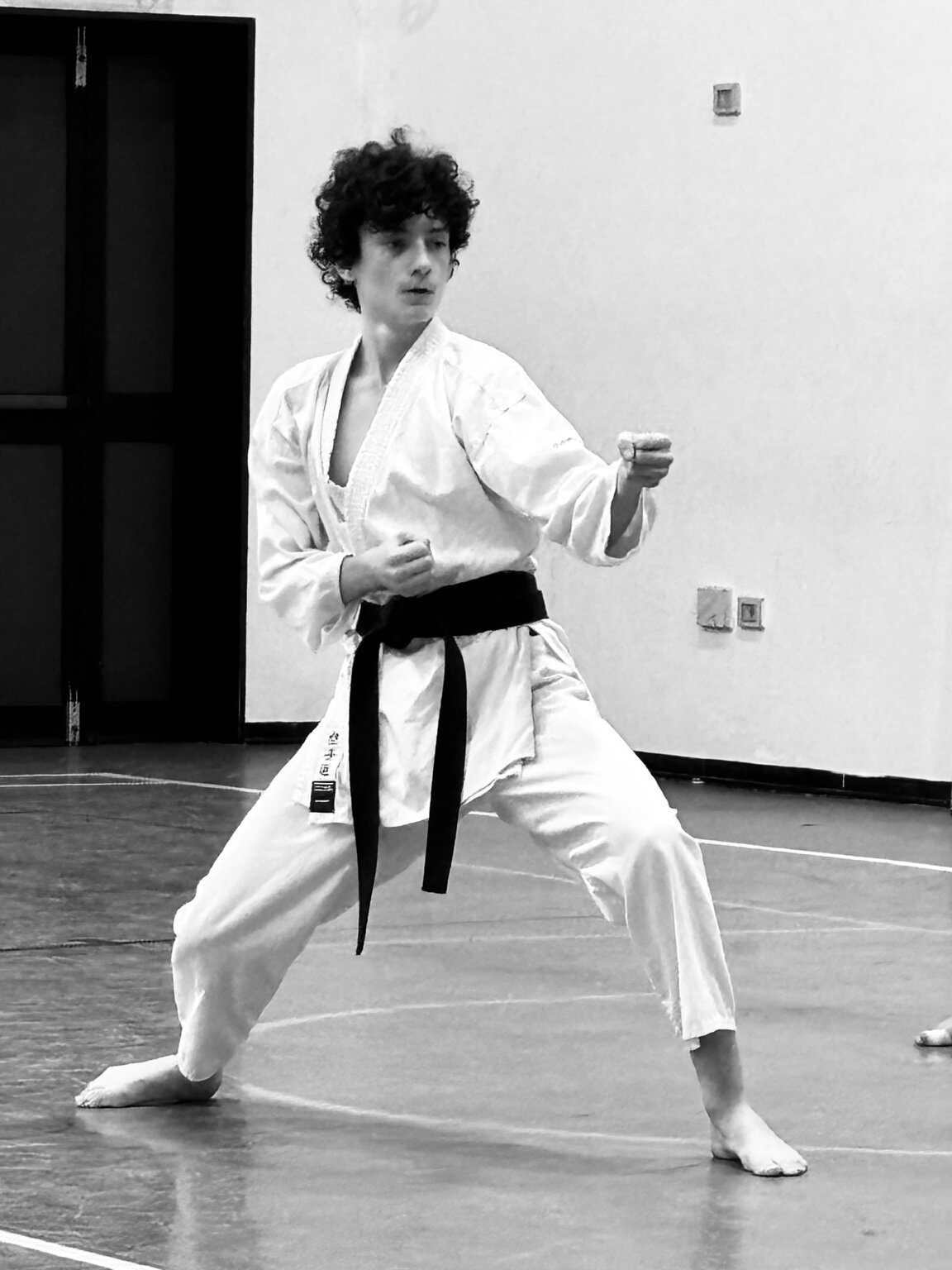 Atleta esegue una tecnica di karate in una foto in bianco e nero